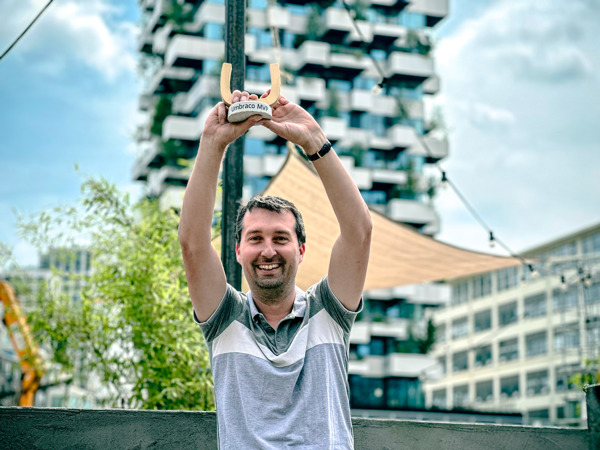 Lachende man houdt buiten een Umbraco MVP-award boven zijn hoofd